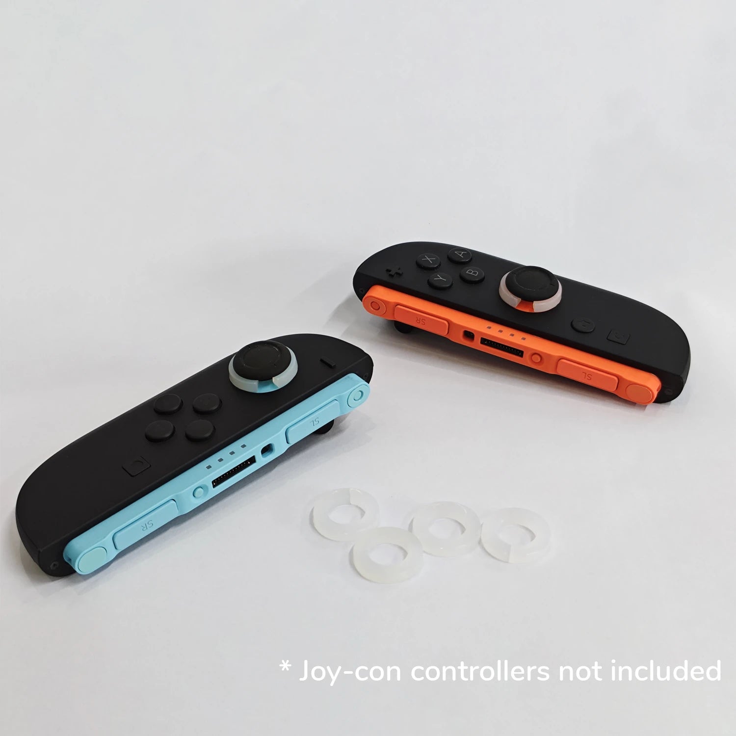 Two gaming controllers, one black and blue, one black and orange, on a light gray background with 'Joy-con controllers not included' text.